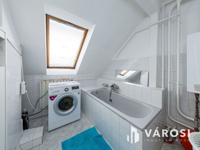 Látszó fagerendás tetőtéri lakás csendes utcában